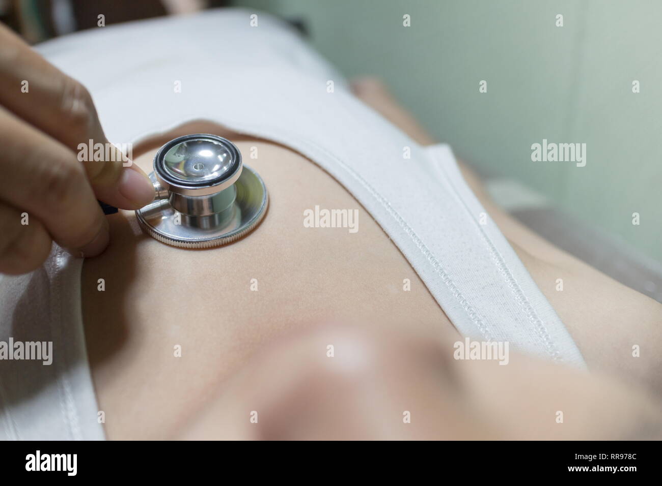 The Doctor examining asian girl and listen heartbeat with stethoscope in the hospital. Stock Photo