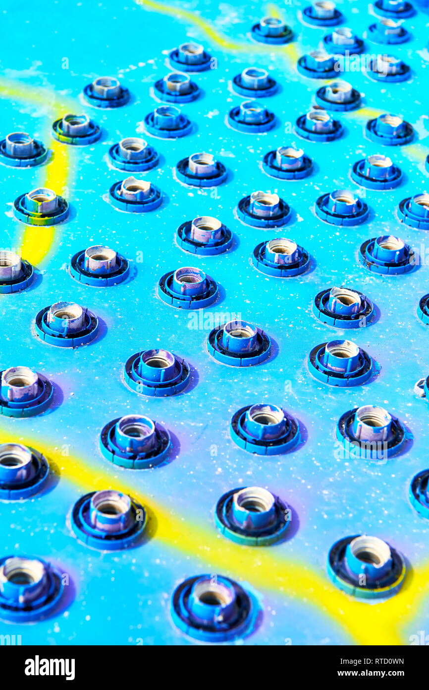 Close-up of a group of broken LED light bulbs still in the sockets attached to a colorful blue and yellow background Stock Photo