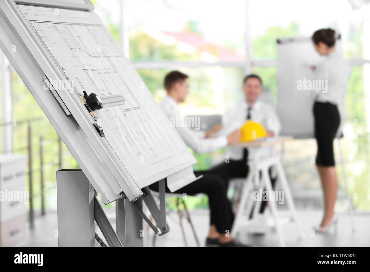 Drawing board with architectural project and engineers on blurred background Stock Photo