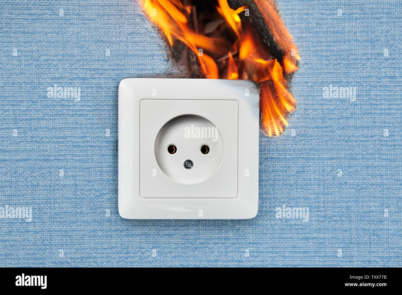 Faulty outlets, fire from electrical appliances malpractice. Burnt damaged plug socket causes home fire. Stock Photo