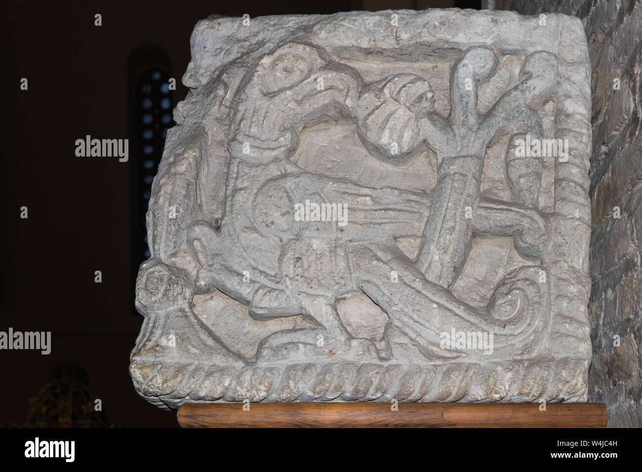 An ancient bas-relief of the mythological Scandinavian, Celtic, Slavic Griffon bird carved on the stone. The decorative element of the decoration of t Stock Photo