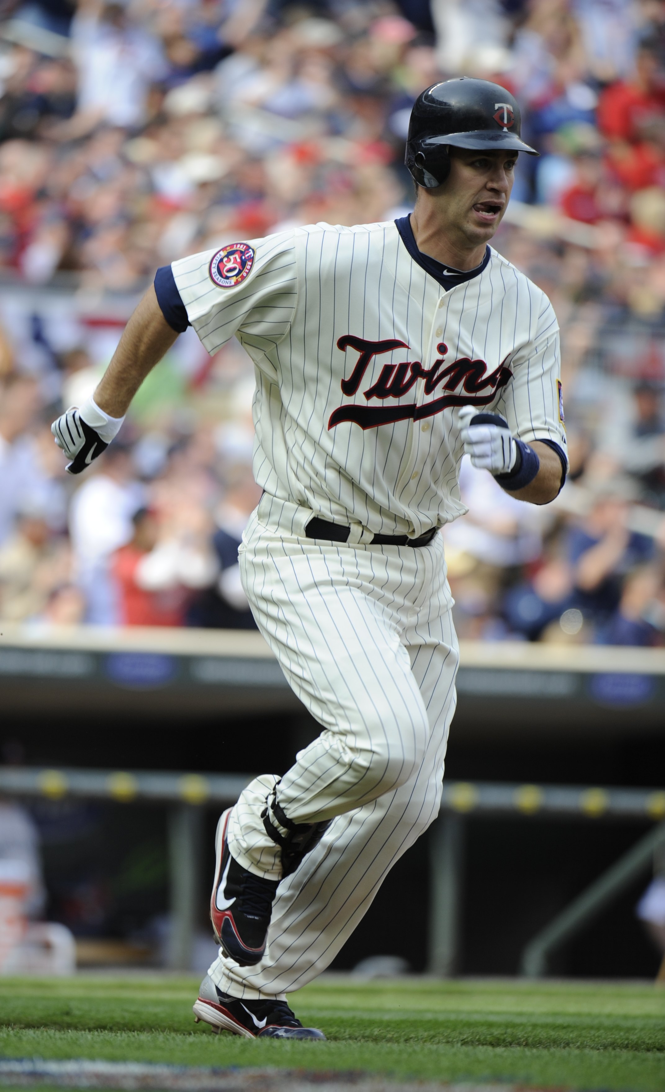 MINNEAPOLIS, MN - APRIL 12: Joe Mauer #7 of the Minnesota Twins runs towards first base after hitting an RBI double in the second inning against the Boston Red Sox during the Twins home opener at Target Field on April 12, 2010 in Minneapolis, Minnesota. (