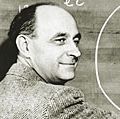 Italian-born physicist Dr. Enrico Fermi draws a diagram at a blackboard with mathematical equations. circa 1950.