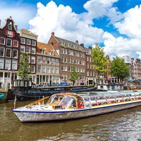 Boat travels down a canal in Amersterdam, The Netherlands