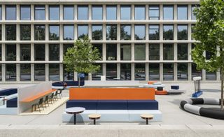 Unifor installation by OMA featuring an office-style set-up outside a building.