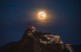 The Hunter's Moon rises in the sky over Jiangzi Zongshan Castle on October 17, 2024 in Shigatse, Xizang Autonomous Region of China as photographed by Zhang Zhenqi