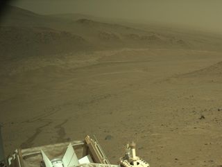 A brownish landscape with a metal structure in the foreground.