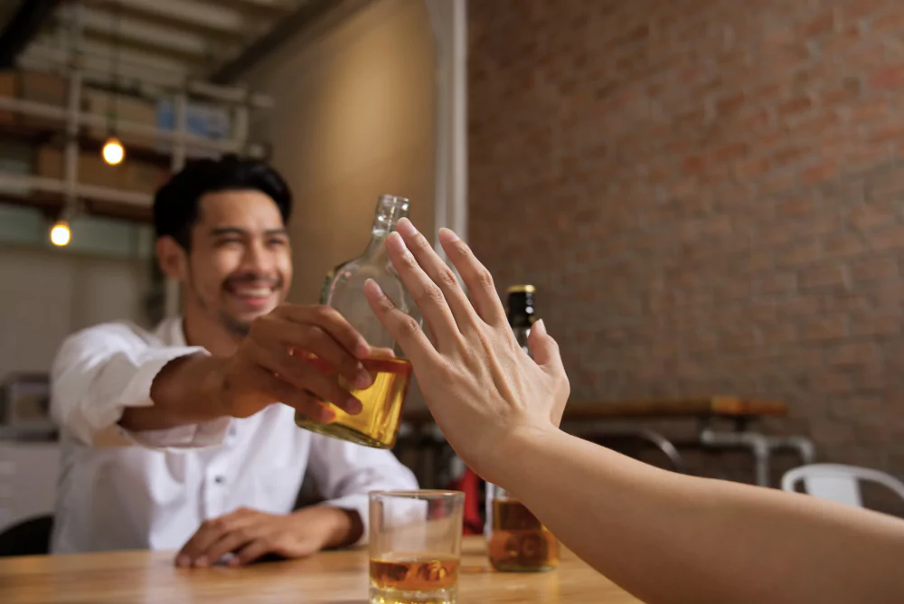 A man, holding a bottle of alcohol