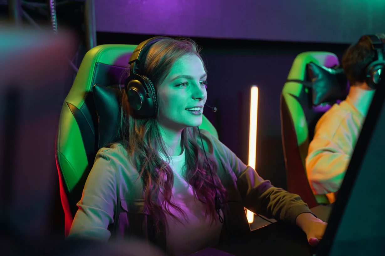 A woman wearing headphones is seated in a gaming chair