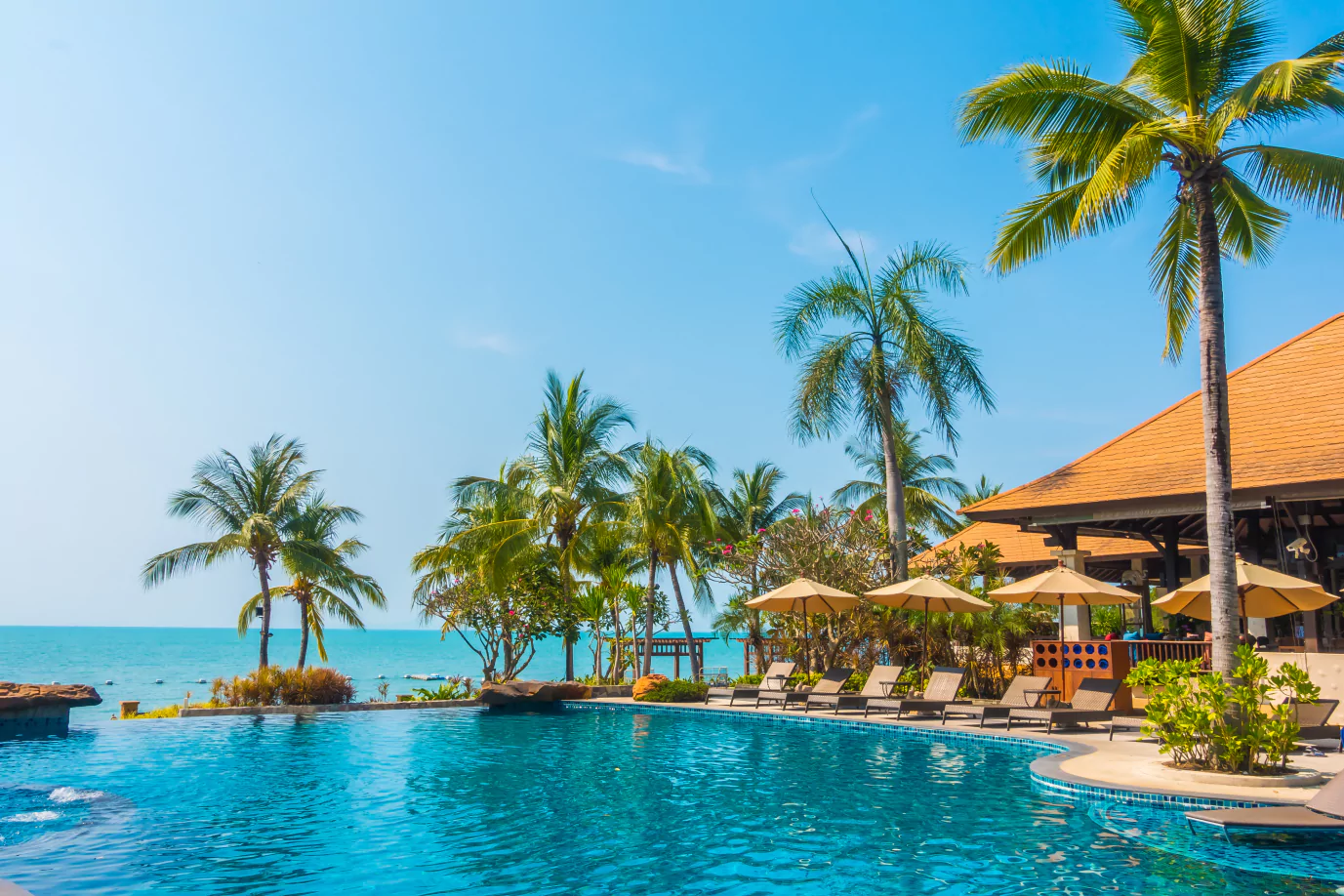 A picturesque resort pool surrounded by lounge chairs and umbrellas