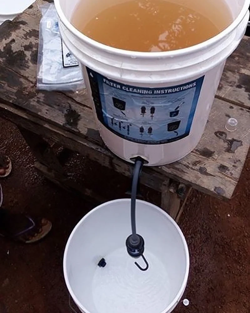 A Sawyer bucket gravity filtration system cleans visually dirty and undrinkable water into clear clean drinking water