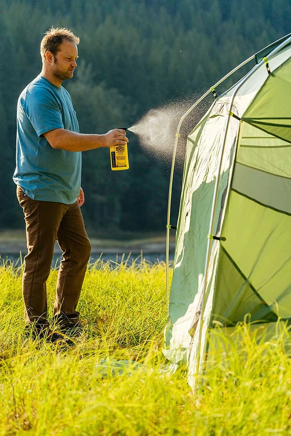 A gentleman treats his tent with Sawyer Permethrin Fabric Insect Repellent for clothing and gear