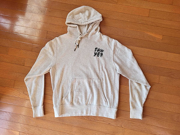 A oatmeal colored hoodie with Sawyer logo on front