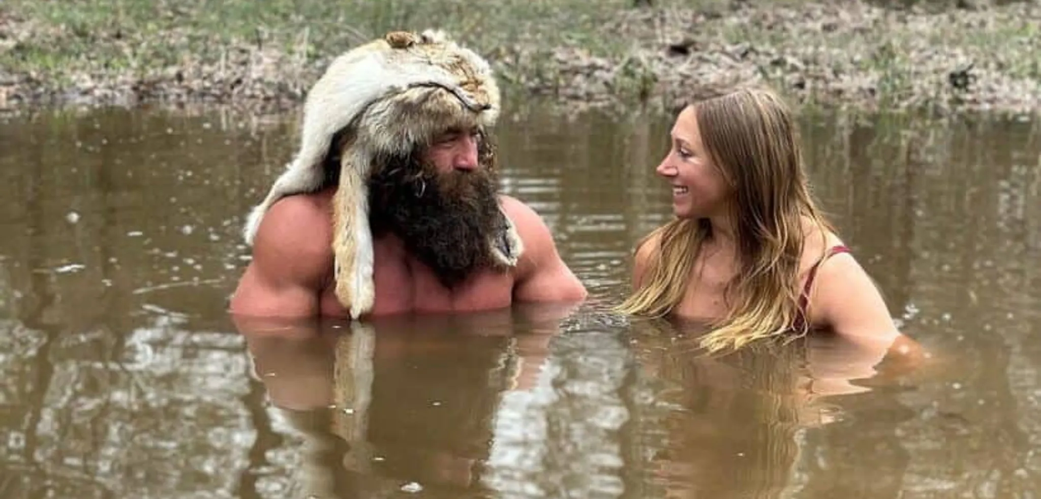 Liver King and Wife, wading in chest deep water, looking affectionately at each other