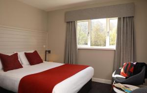 a hotel room with a bed and a window at The Isles of Glencoe Hotel in Glencoe