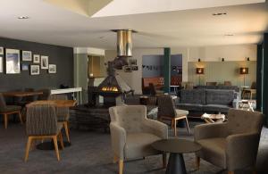 a living room with a couch and chairs and a fireplace at The Isles of Glencoe Hotel in Glencoe