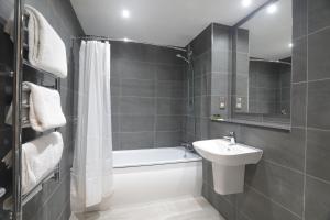 a bathroom with a sink and a tub and a toilet at The Isles of Glencoe Hotel in Glencoe