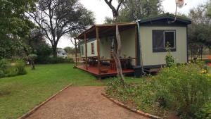 a tiny house with a porch in a yard at Grootgeluk in Naboomspruit