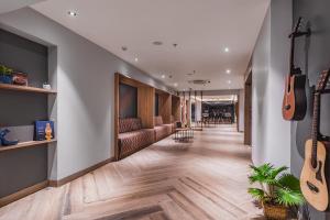 a long corridor with guitars on the wall and a room filled with furniture at Ginger Bharuch in Bharuch