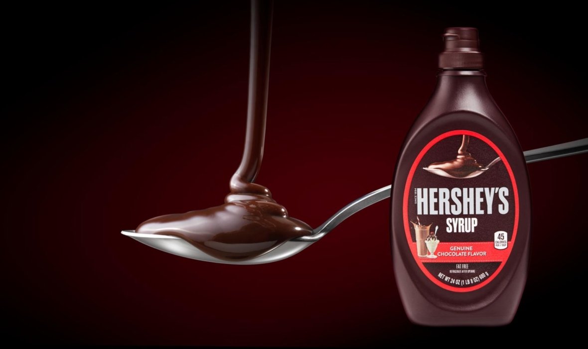 Chocolate syrup drizzling on to a spoon with a dark background on packaging