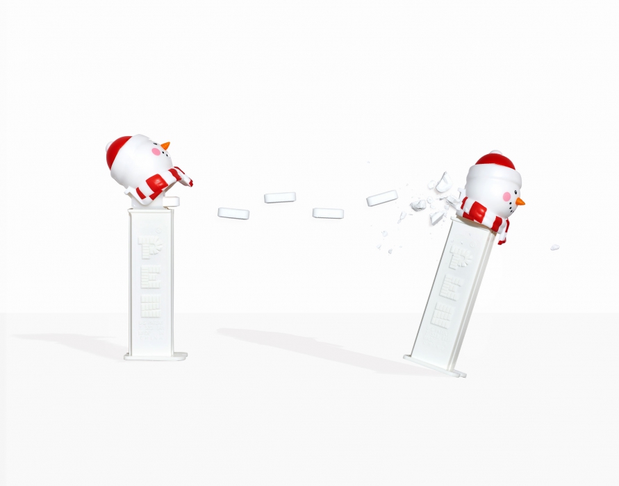 A pez snowman throwing white pez at another pez snowman - food candy photography