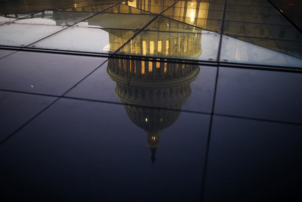 The U.S. Capitol is seen reflected in the windows of the Capitol Visitors Center as lawmakers work to avert a government s...