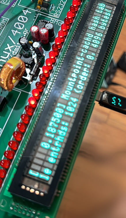 Linux/4004 board with the VFD display showing a corrupted Linux kernel boot console