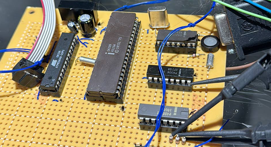 A picture of a protoboard with a few MCS-04 chips on it in sockets and an ATMEGA48 as well