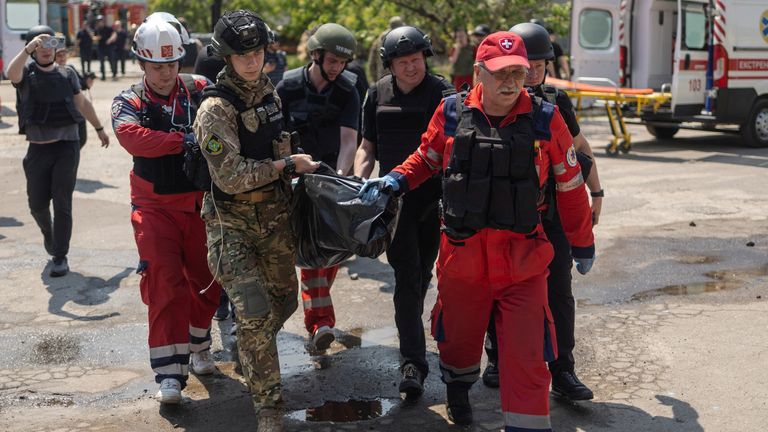 Emergency workers carry the body of a person killed by Russian missile strikes at a compound of a printworks, amid Russia's attack on Ukraine, in Kharkiv, Ukraine May 23, 2024. REUTERS/Valentyn Ogirenko