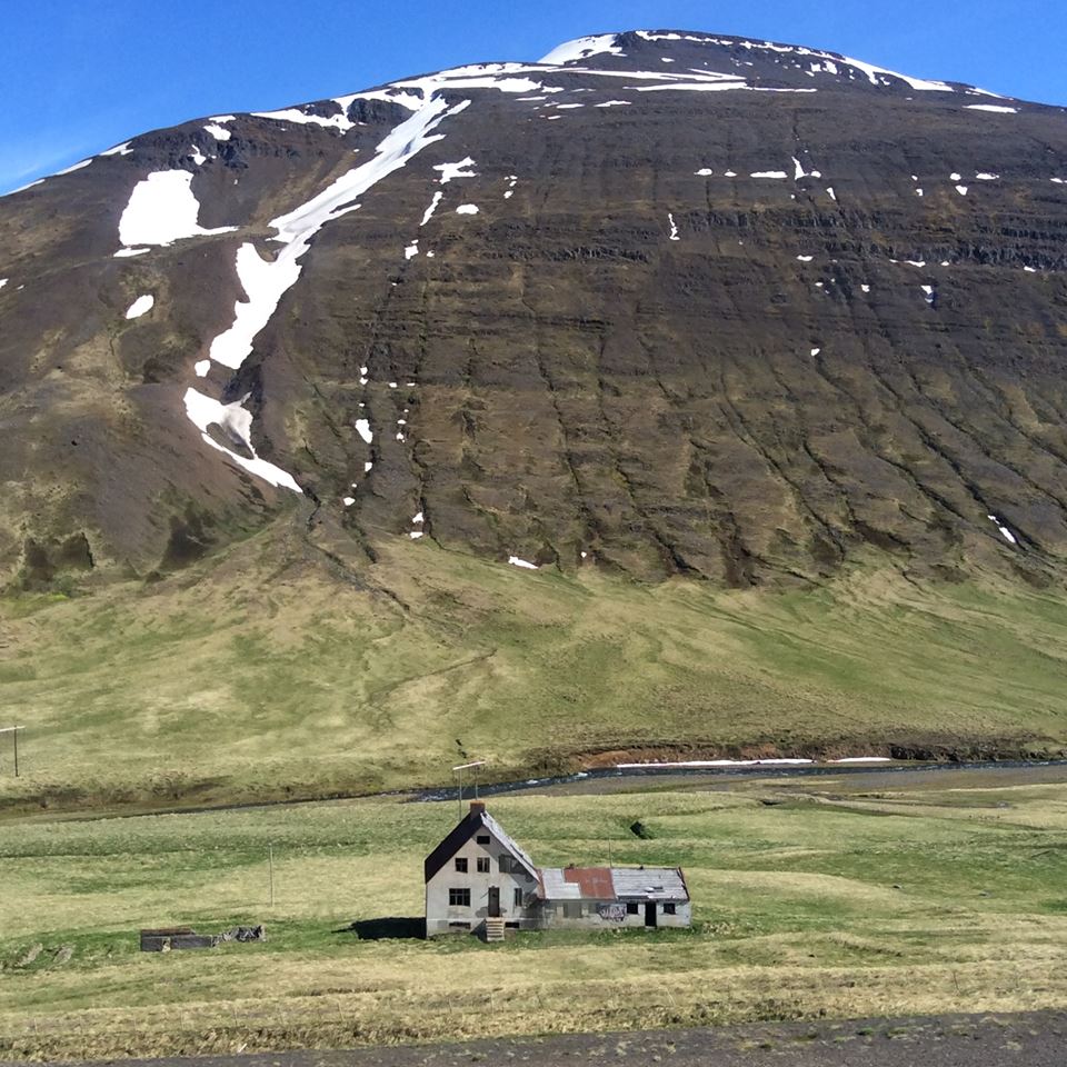 An image of a house in front of a mountain