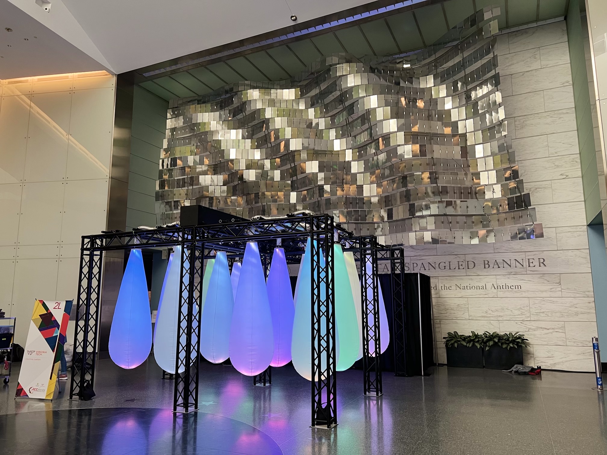 A photo of Celestial Garden right after it was set up. Sixteen pods were attached to a metal frame. The pods have a speaker and lightstrips inside of them and reacts to movements (poke, bump, even from draft when walking past) by changing colour and creating dynamic soundscapes.