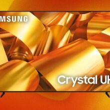 A Samsung TV appears on an orange and yellow abstract background, with golden ribbons on its screen.