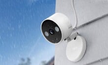 a home security camera on a home's exterior in rainy weather