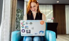 woman working on laptop covered in stickers