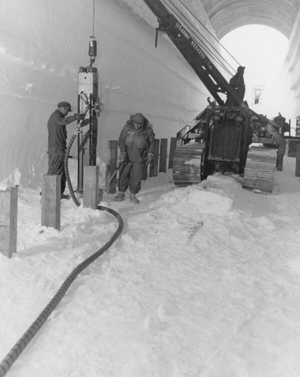 Crew use a pile-driver to install the foundation for water storage tanks at Camp Century.