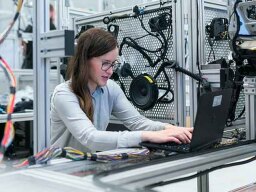 woman working on computer surrounded by machines