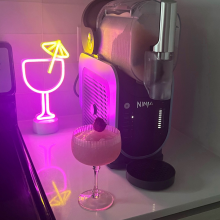 Ninja Slushi frozen drink maker. margarita glass, and neon light decoration sitting on countertop