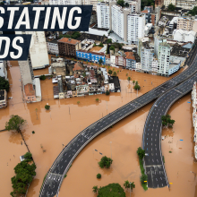 Drone footage shows an urban road submerged under water. Caption reads: "Devastating floods"