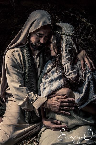 a man and woman sitting next to each other on the ground with their ...