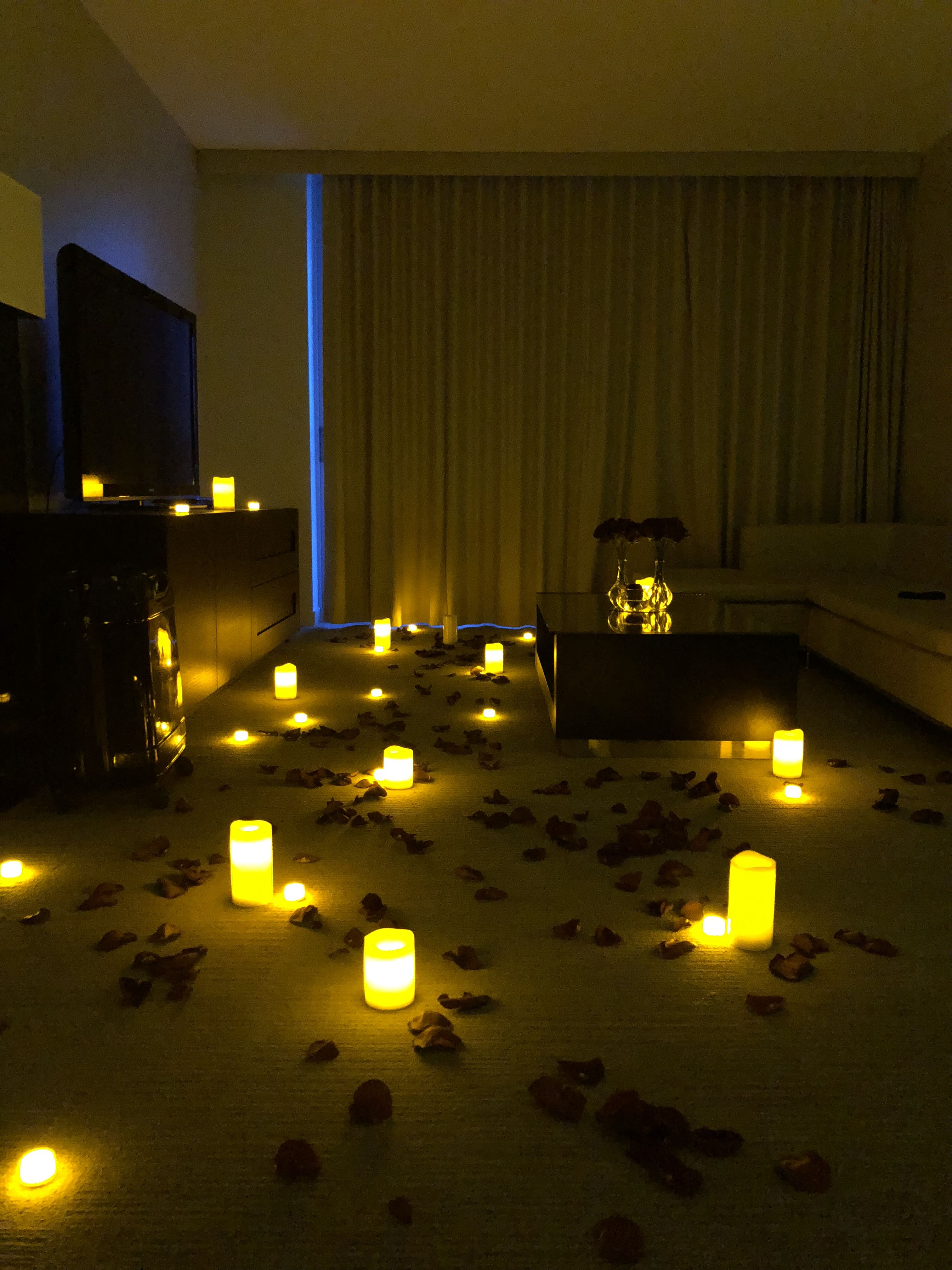 The romantic hotel room decoration with real rose petals, candles ...