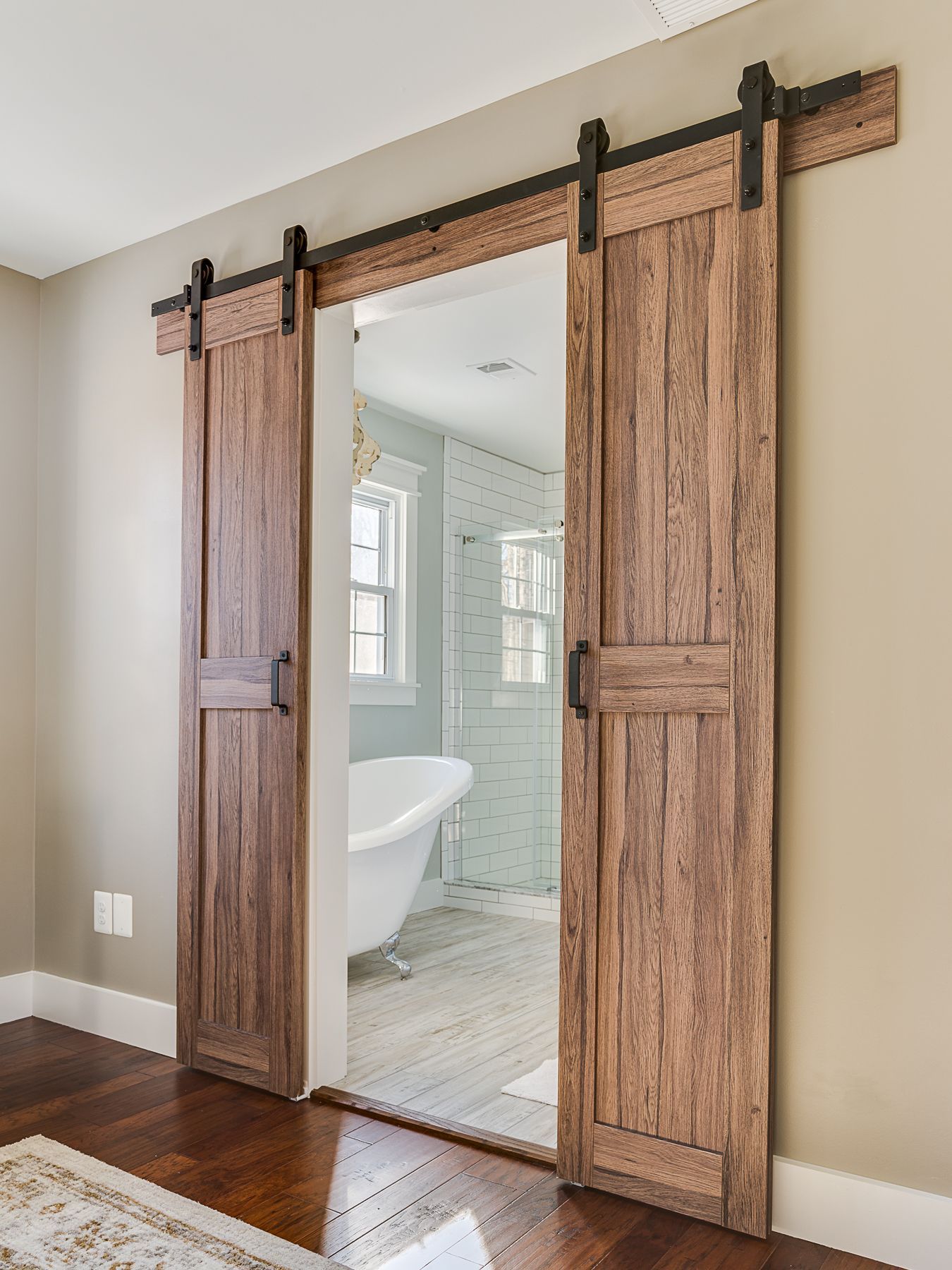 Barn doors leading into master bathroom in a modern farmhouse Bathroom ...