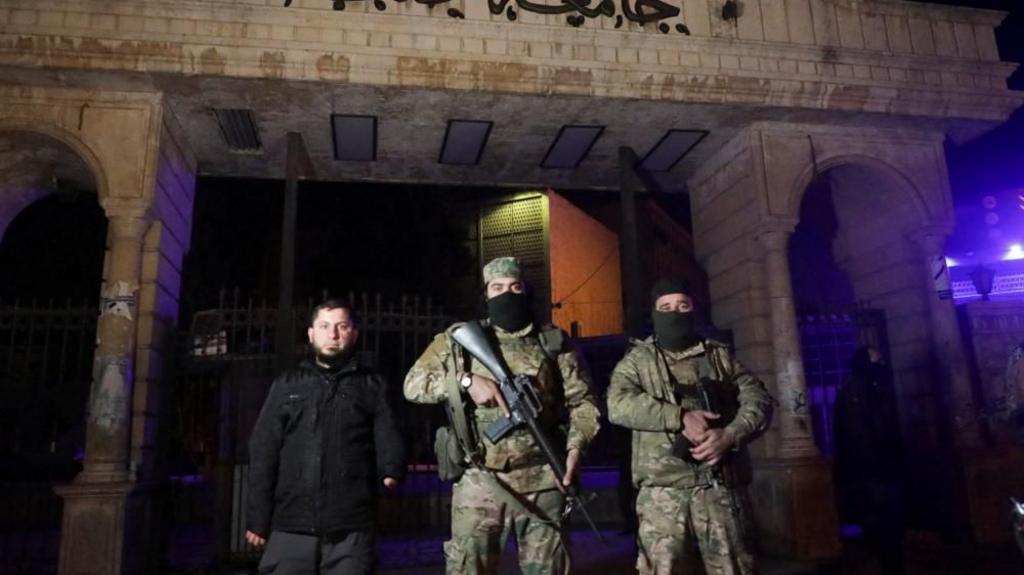 Syrian opposition fighters stand in front of University of Aleppo