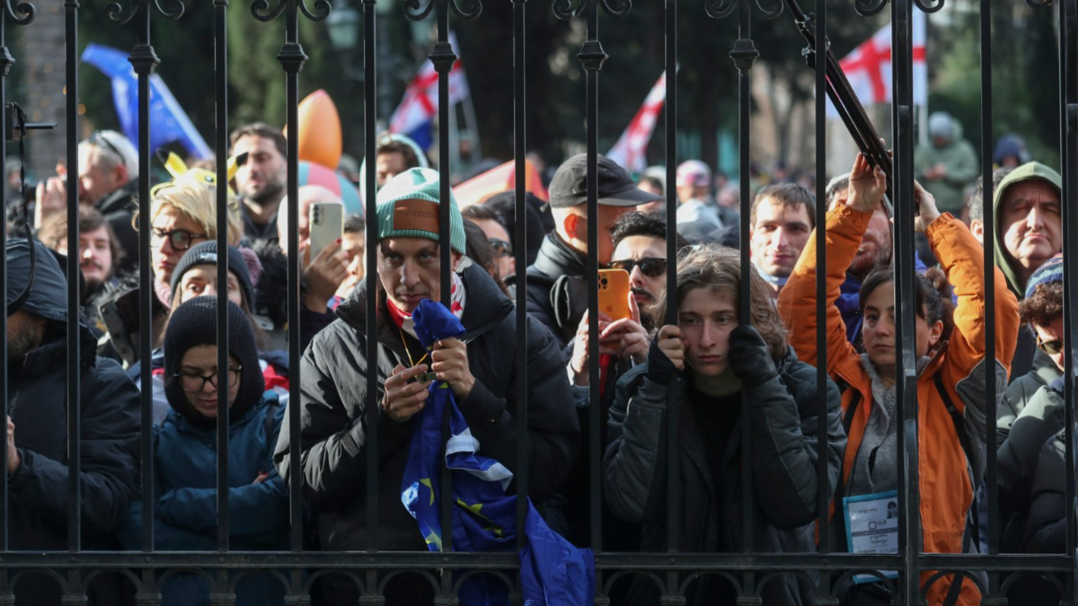 People listen to outgoing Georgian President Salome Zourabichvili's statement outside the Orbeliani Palace in Tbilisi, Georgia, 29 December 2024