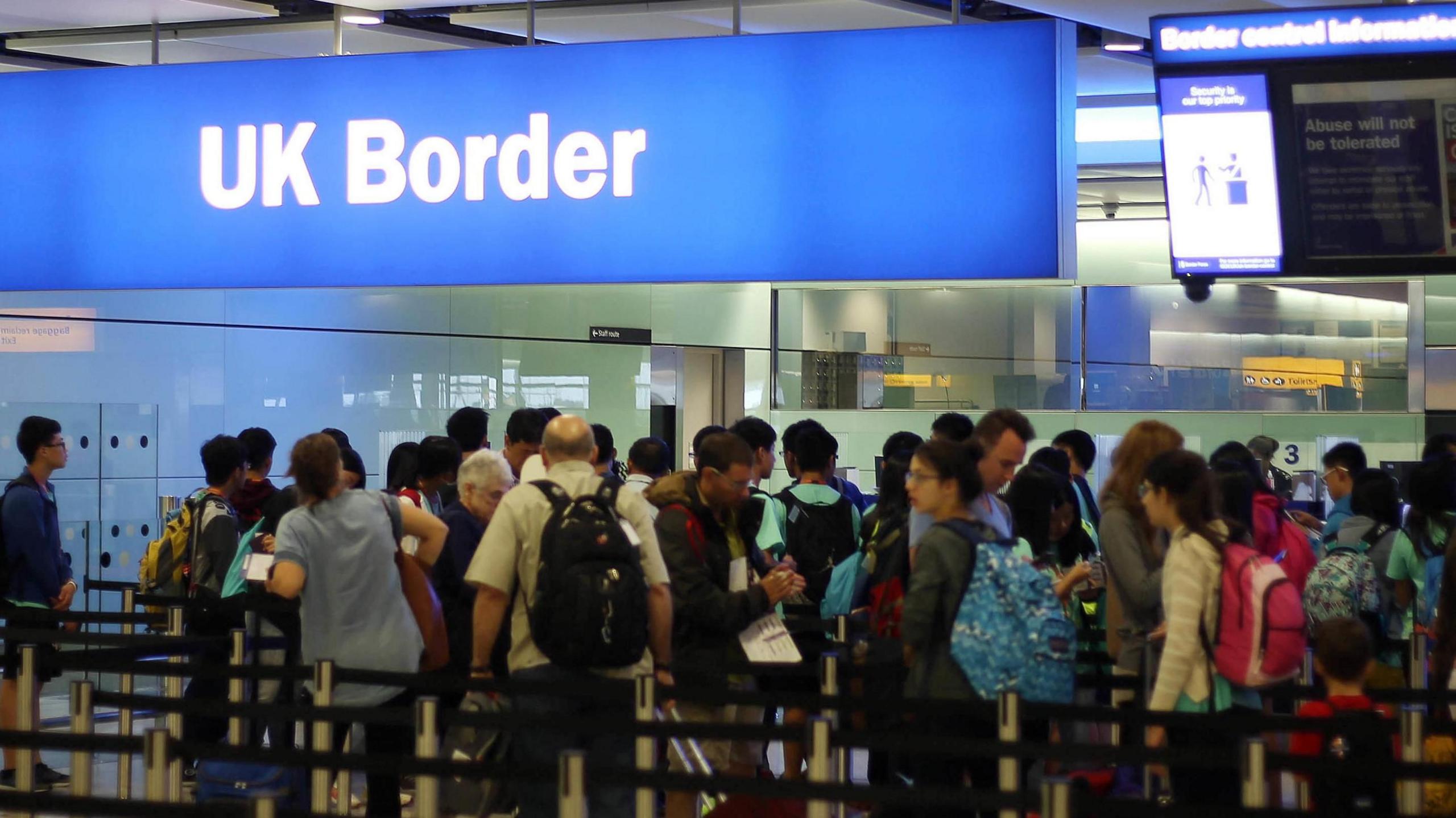 Lots of people queue at the UK border at Heathrow Airport in London.