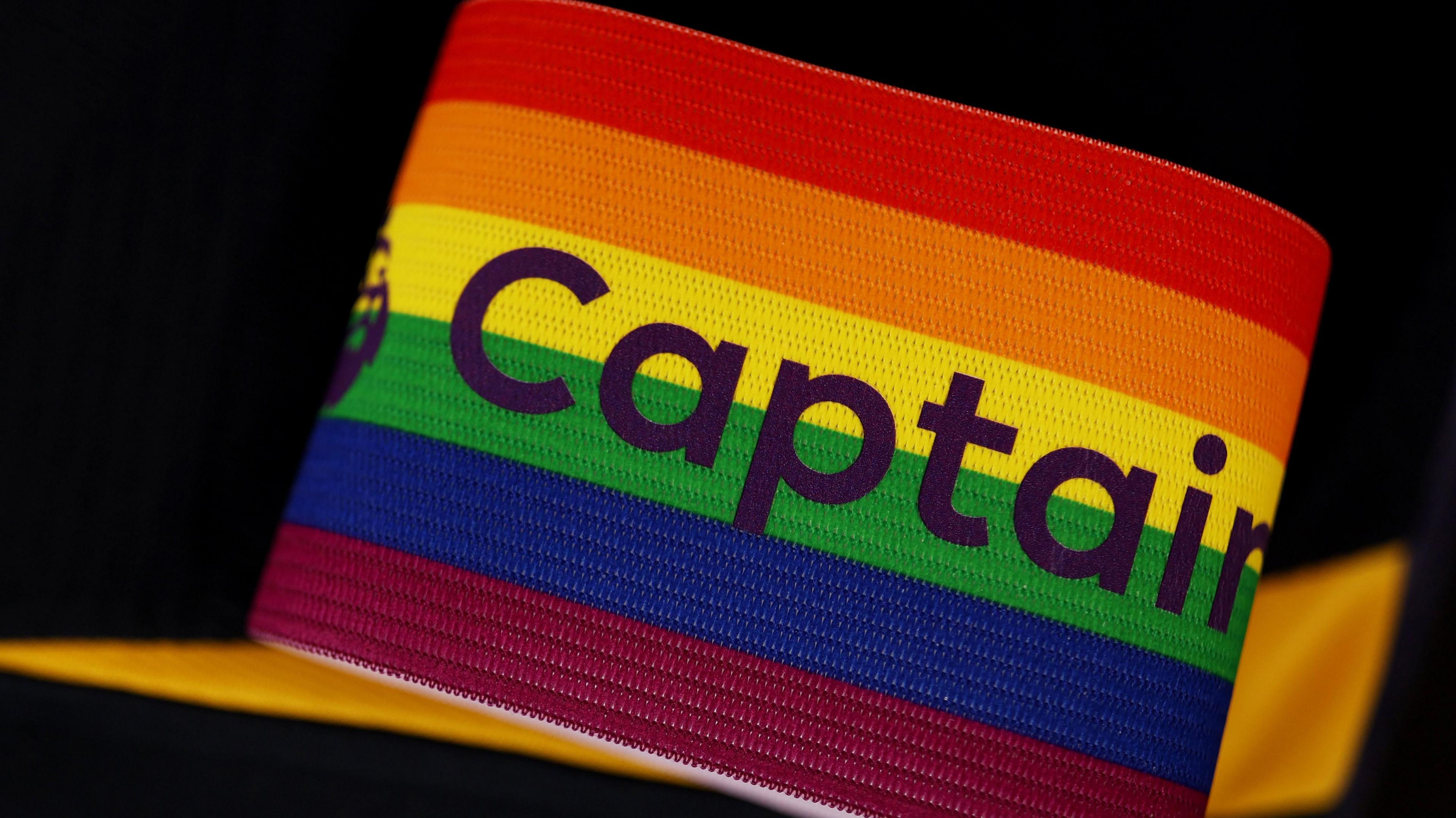 A rainbow-coloured Premier League captain's armband sits in front of a black background