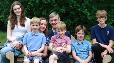 Jacob Rees-Mogg pictured on a bench with his wife and five of his kids 