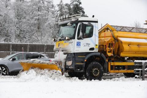 A snow plough and gritter clears snow on the M80 near Castlecary, North Lanarkshire, Scotland.