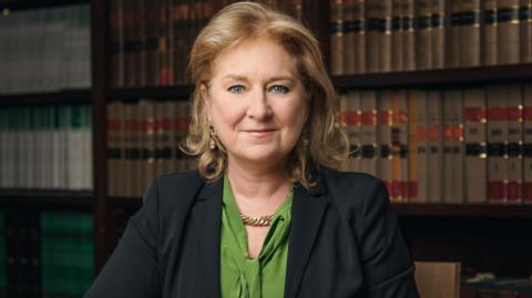 Baroness Sue Carr, lady chief justice of England and Wales, looking at the camera with full bookshelves behind her 