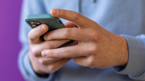 A young man holding a phone stock image