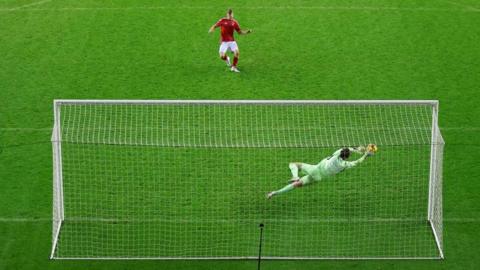 Wigan goalkeeper Tom Watson saves Kyle McAdam's penalty